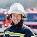 Feuerwehrmann im Portrait mit Feuerwehrhelm