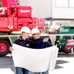 Industriefotografie zwei Bauleiter besprechen während der Verladung über einen Plan