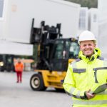 Bauleiter überwacht die Verladung eines Containers auf dem Lager eines Container Unternehmens