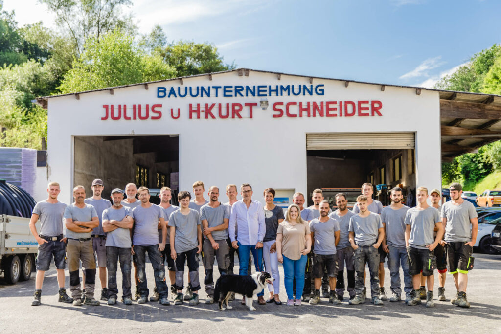 Gruppenbild vor der Garage von Schneider Projektbau.