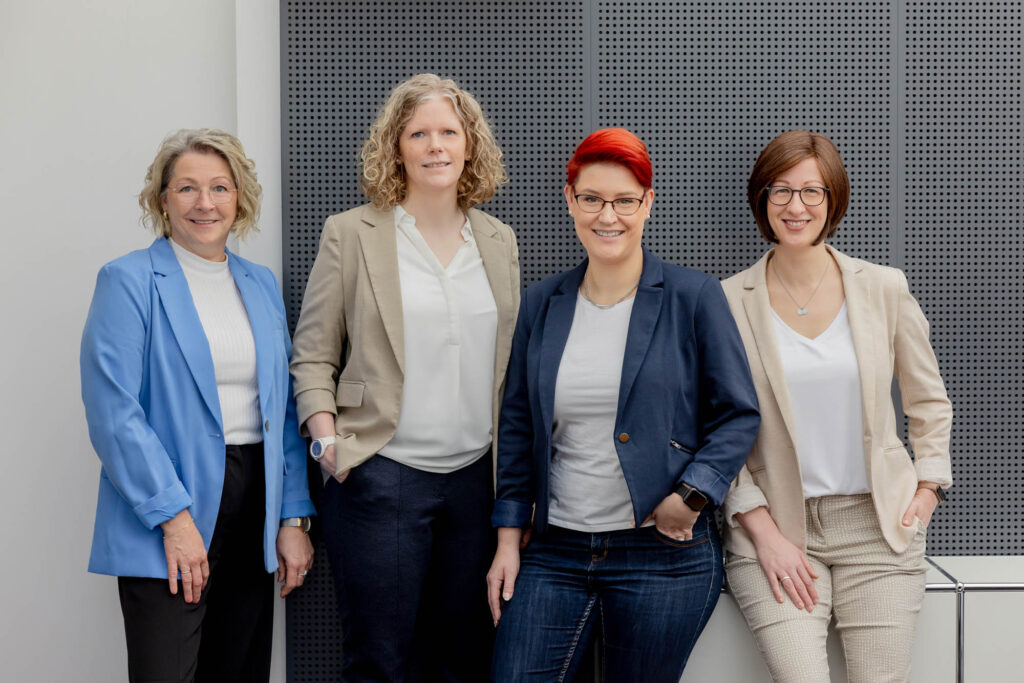 Teamfoto von vier Frauen. Sie lachen.