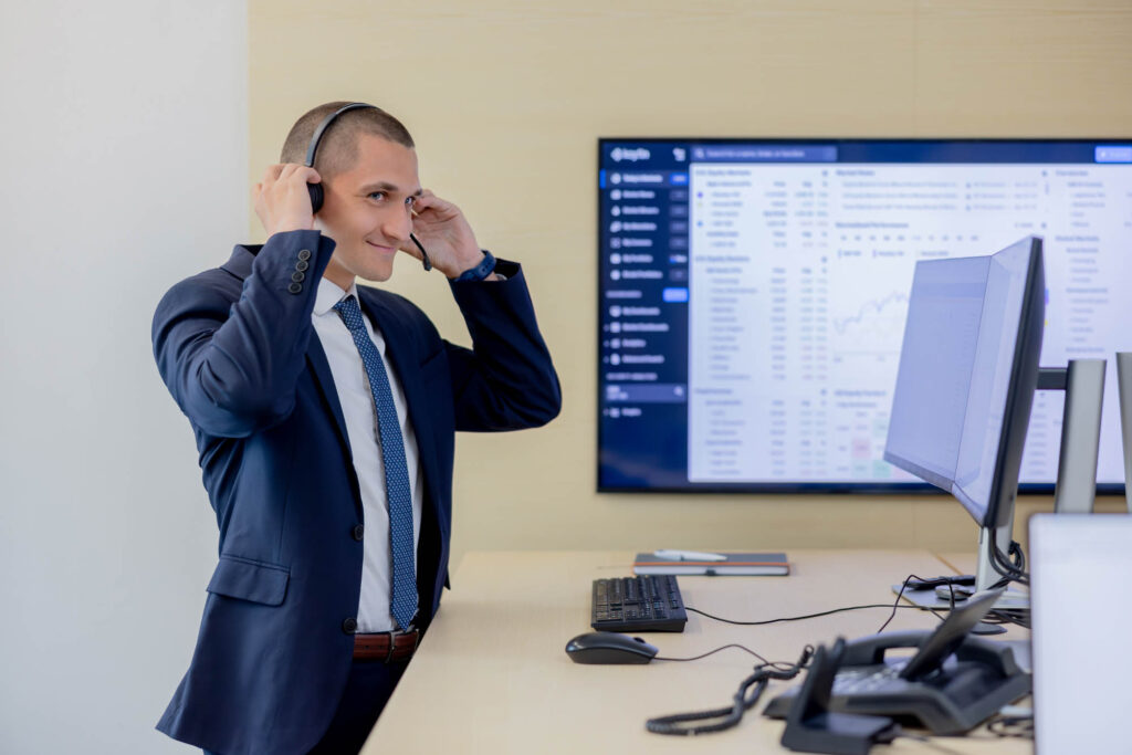 Imagebild eines Vermögensberaters bei der Volksbank Oberberg. Er steht an einem Schreibtisch und zieht ein Headset an.