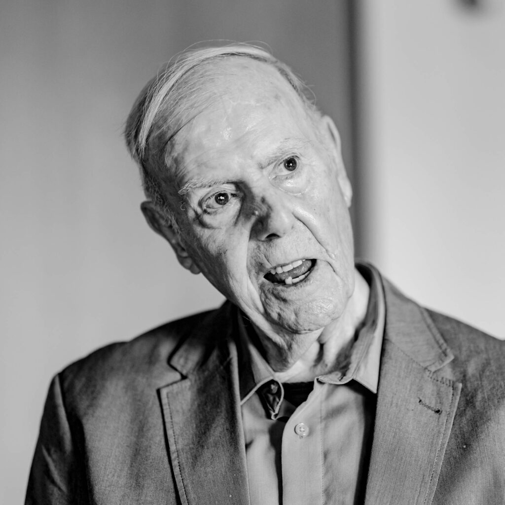 Schwarz-weiß Portrait eines älteren Mannes. Er legt den Kopf schief und schaut zur Seite.