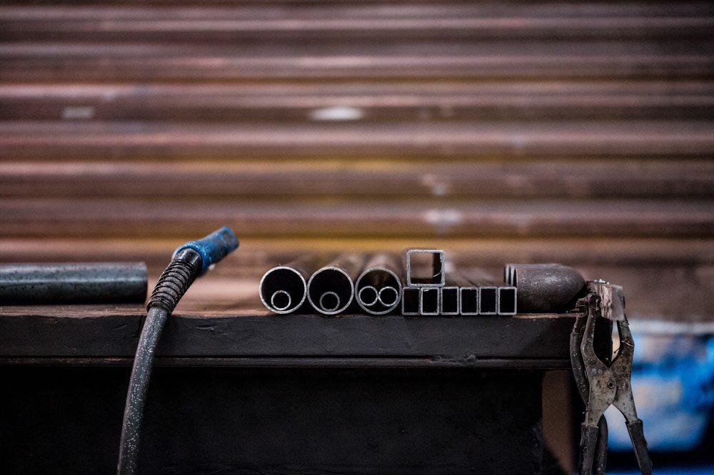 Industriefotografie Detailaufnahme von Metall auf dem Schweißtisch mit dem Schweißgerät
